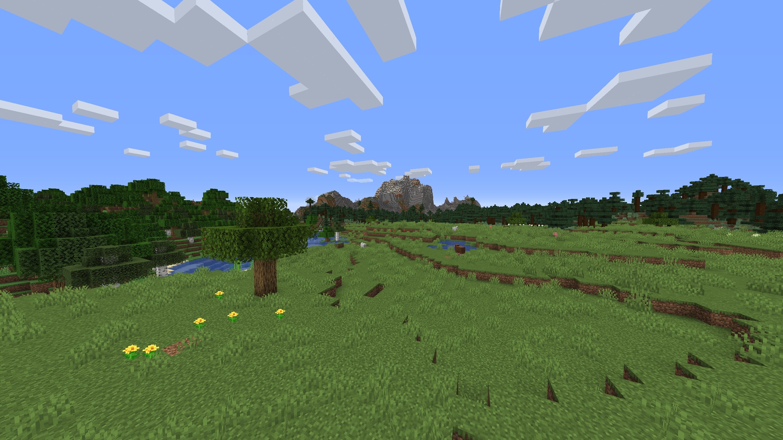 The 1.15.2 world with one oak tree in the middle of a plains with a mountain in the distance